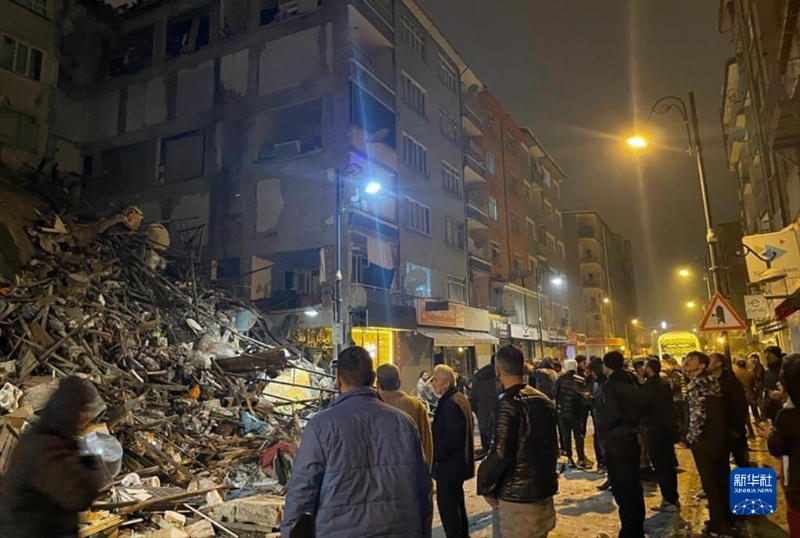 2月6日，在土耳其卡赫拉曼馬拉什省帕扎爾哲克，人們聚集在倒塌的建筑物旁。（圖源：新華社）