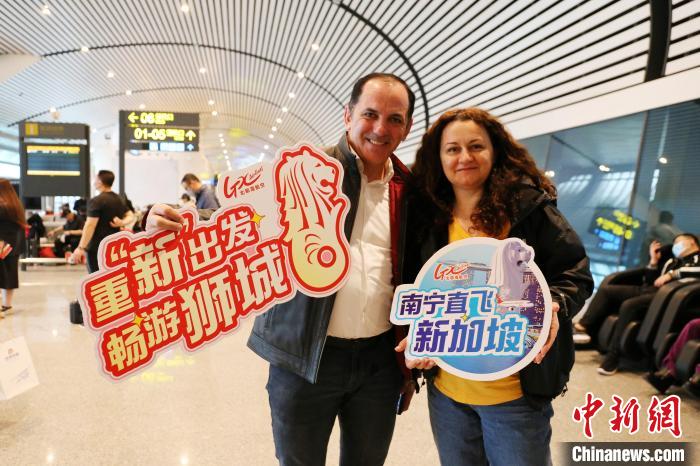 圖為乘坐南寧至新加坡航班的外籍旅客拍照留念?！↑S秉柱 攝