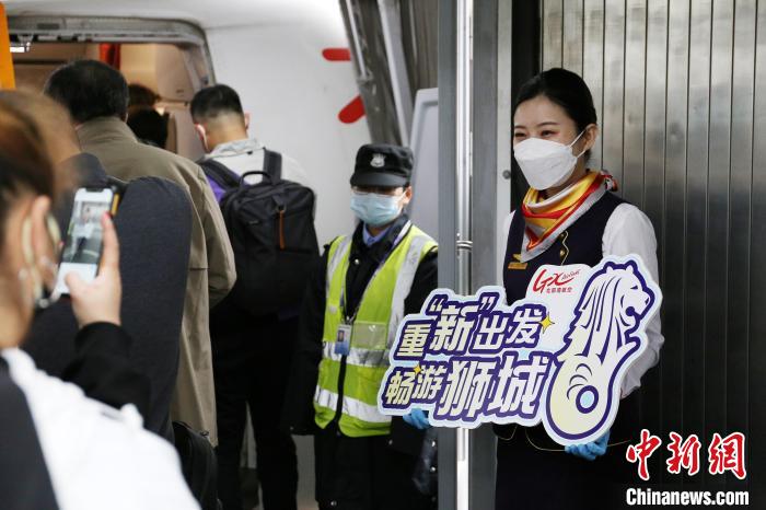 圖為北部灣航空乘務(wù)員在飛機艙門迎接旅客?！↑S秉柱 攝