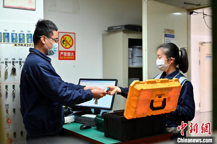 圖為咸俊領(lǐng)取工具?！∮峋?攝