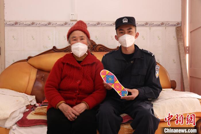 圖為羅金娥(左)與民警合影?！∥纳竭吘彻芾碇ш?duì)供圖