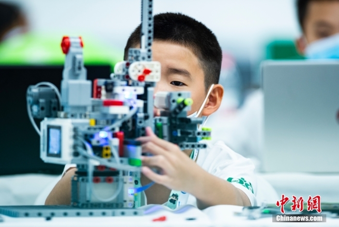 資料圖：一名參加青少年機(jī)器人設(shè)計(jì)大賽的小選手專注調(diào)試自己的機(jī)器人。 <a target='_blank' href='/'>中新社</a>記者 侯宇 攝