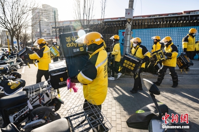 圖為外賣送餐員在北京市朝陽區(qū)的街頭開完早會后投入工作。 <a target='_blank' href='/'>中新社</a>記者 侯宇 攝