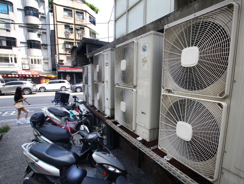 臺灣第二核能發(fā)電廠2號機(jī)14日期滿除役，外界擔(dān)心影響供電。圖為一位民眾走過成排的冷氣室外機(jī)。（圖源：臺灣“中時新聞網(wǎng)”）