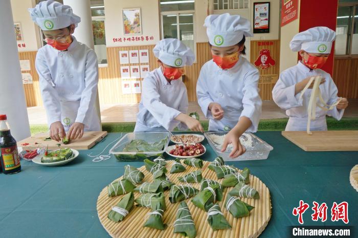 圖為鄭州小學(xué)生體驗包粽子。(資料圖) 韓章云 攝