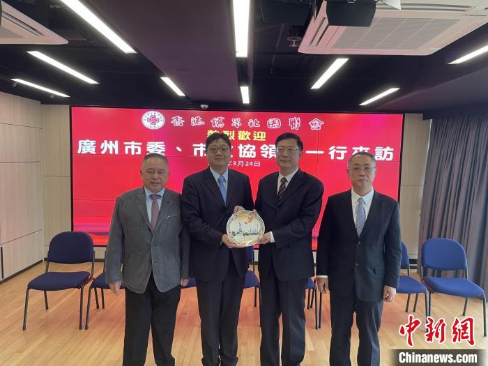 中共廣州市委常委、統(tǒng)戰(zhàn)部部長(zhǎng)王世彤(右二)向香港僑界社團(tuán)聯(lián)會(huì)會(huì)長(zhǎng)黃楚基(左二)致送紀(jì)念品?！∠愀蹆S界社團(tuán)聯(lián)會(huì)供圖