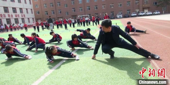 圖為“校長(zhǎng)爺爺”與學(xué)生們一起運(yùn)動(dòng)?！￡惙?攝