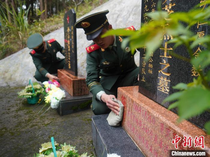 武警官兵為烈士擦去碑前塵土?！∈Y蘇昇 攝