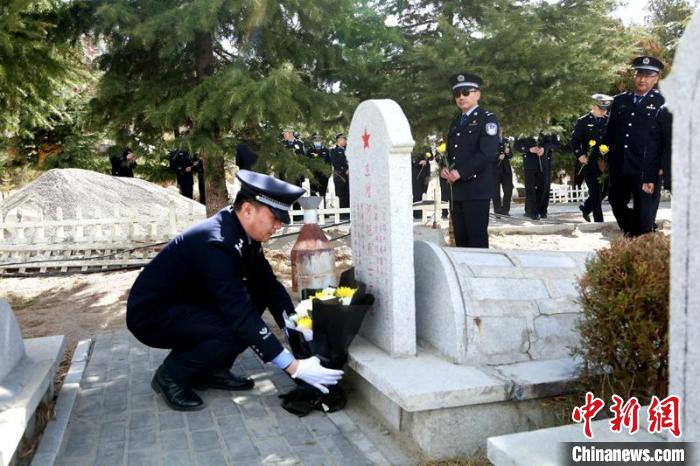 圖為西藏邊檢總站執(zhí)法調(diào)查支隊(duì)民警為旦增阿旺烈士擦拭墓碑、敬獻(xiàn)鮮花。　劉明陽 攝