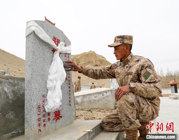 圖為阿里軍分區(qū)某邊防團(tuán)官兵為革命先烈擦拭墓碑。　劉曉東 攝