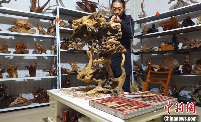 唐永懷正在雕刻作品《國(guó)色天香》?！∶系澱?攝