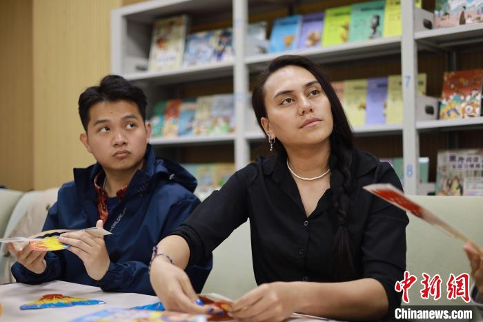 留學(xué)生們正在動(dòng)手制作中國(guó)傳統(tǒng)玩具?！⌒吕俪霭嫔绻﹫D