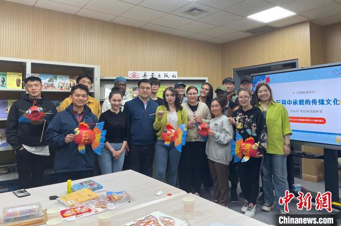 留學(xué)生們手持親手制作的中國(guó)傳統(tǒng)玩具合影留念?！⌒吕俪霭嫔绻﹫D