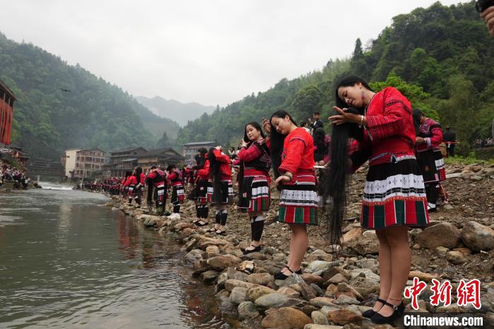 4月22日，在廣西龍勝各族自治縣龍脊鎮(zhèn)黃洛瑤寨，當(dāng)?shù)噩幾迕癖娫诤舆呴_展長發(fā)梳妝表演。　韋吉陽 攝