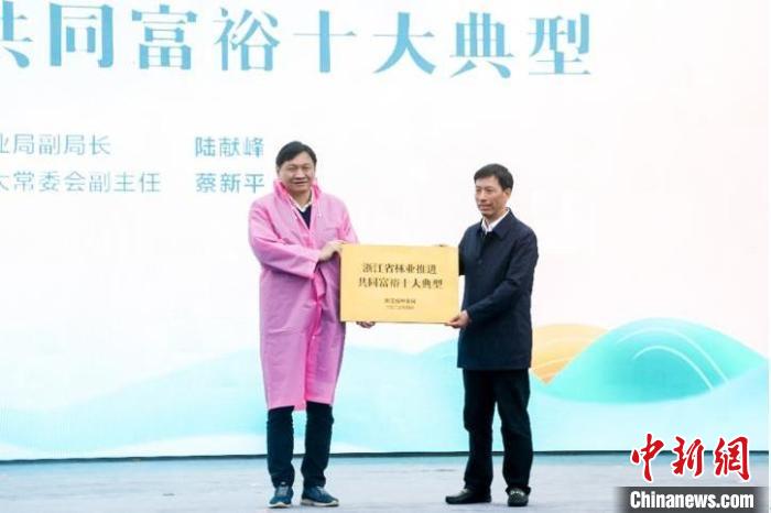 浙江省林業(yè)局副局長陸獻(xiàn)峰(左)為浙江省林業(yè)推進(jìn)共同富裕十大典型授牌現(xiàn)場?！”P峰鄉(xiāng)人民政府 供圖