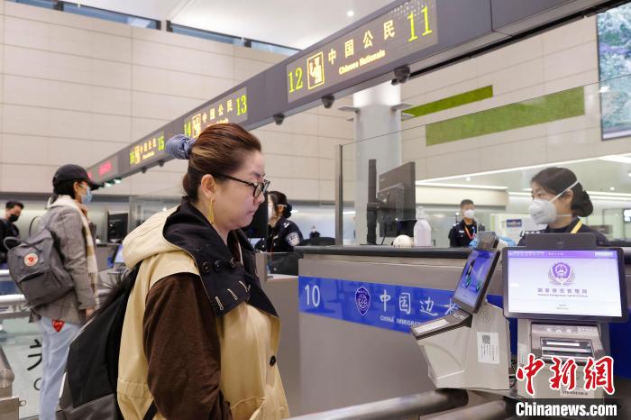虹橋邊檢站民警在對(duì)出境旅客進(jìn)行信息核查。　殷立勤 攝