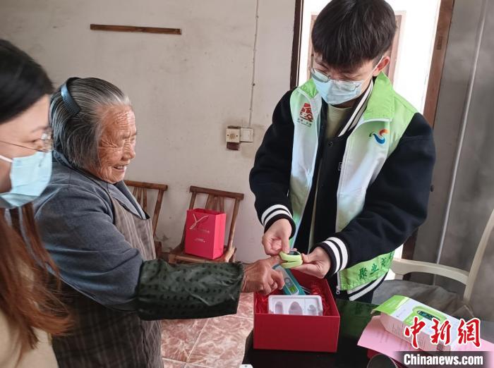 指導(dǎo)僑界老人使用血氧儀?！＄娦?攝