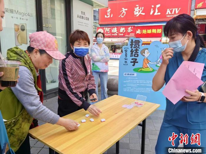 阿姨們熟練地玩起“摜結(jié)子”?！≠Z宇巍 攝