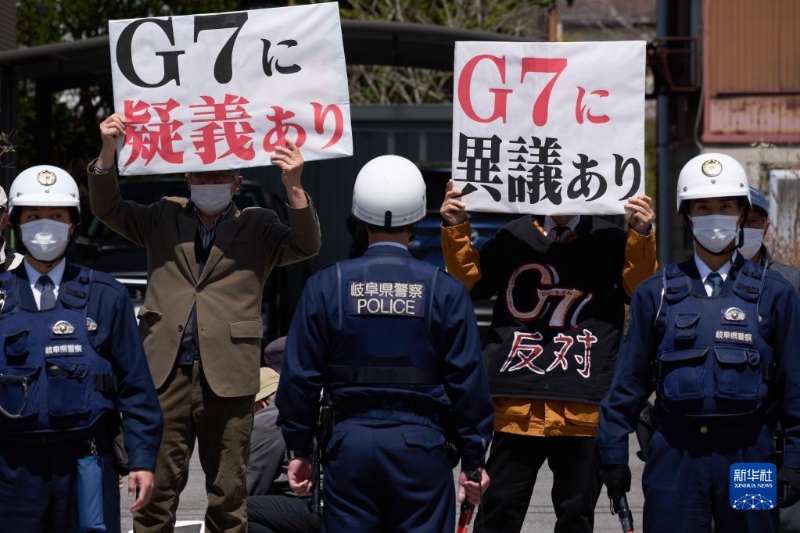 4月16日，在日本長野縣輕井澤車站附近，抗議者手舉標(biāo)語抗議。（圖源：新華社）