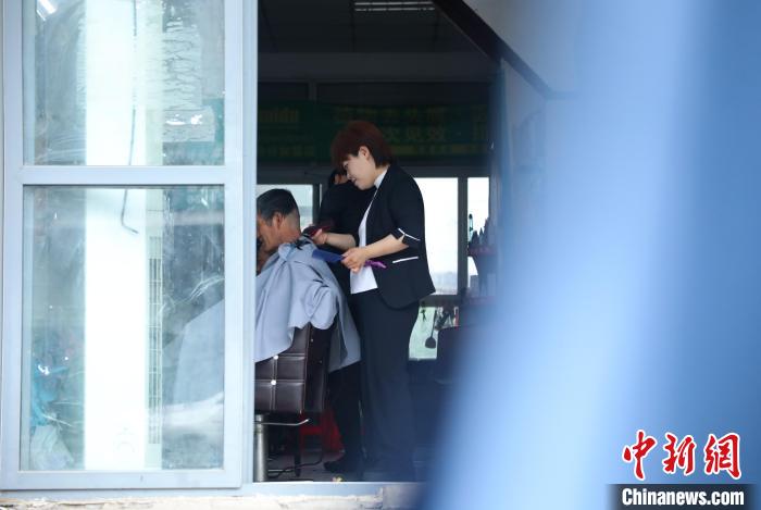 周麗麗正在給客人理發(fā)?！￡惣覙?攝