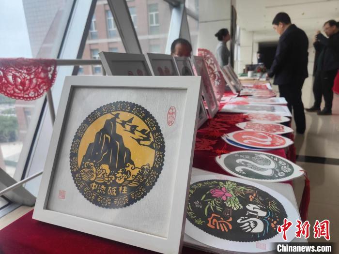 圖為新聞發(fā)布會現(xiàn)場展示的剪紙等產(chǎn)品?！畲笥?攝