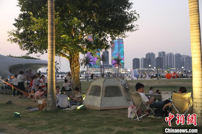“立夏”時(shí)節(jié)，市民游客在海口灣戶外草坪露營(yíng)納涼?！?jiān)潞?攝