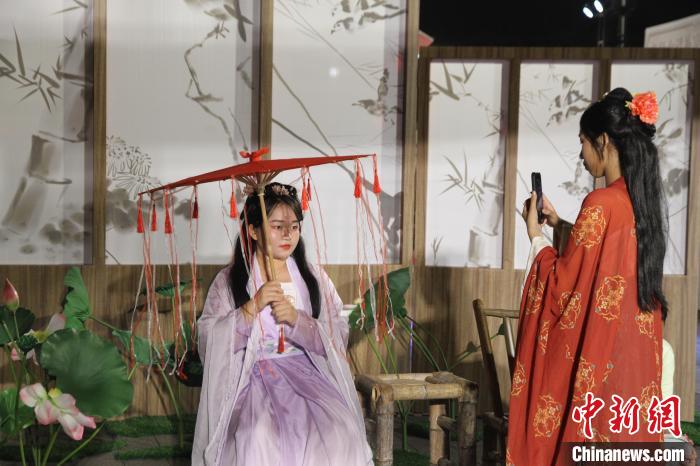 圖為市民游客在海口古風(fēng)市集體驗(yàn)漢服，拍照打卡?！?jiān)潞?攝