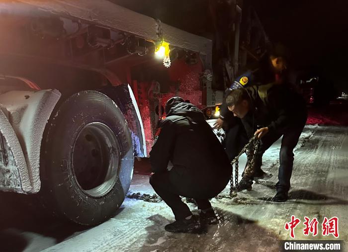 圖為民警幫助受困車輛安裝防滑鏈?！」逯菸麄鞑抗﹫D
