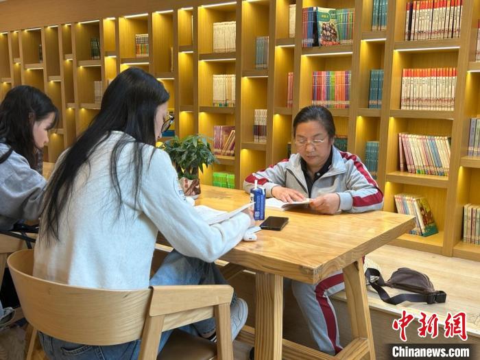 圖為22日，左桂香(右一)在新建區(qū)抱樸書屋閱讀?！≈飕?攝