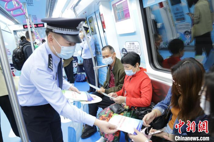民警向乘客發(fā)放宣傳資料，講解防范經(jīng)濟(jì)犯罪的知識(shí)。　廣西公安廳供圖