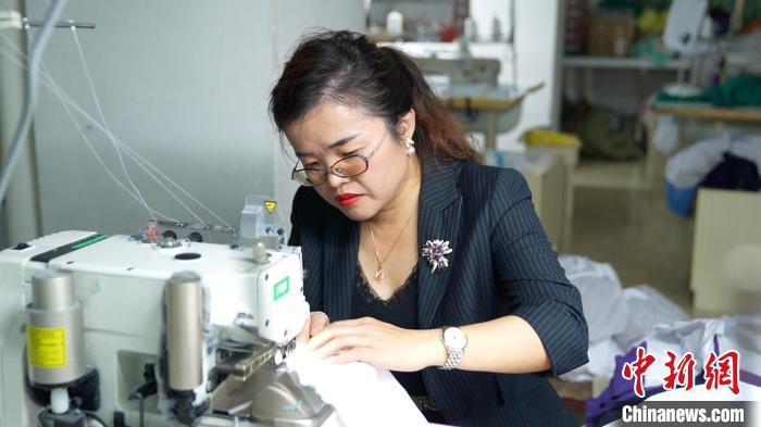 圖為李王花上機操作縫紉服裝?！￡愑⑶?攝