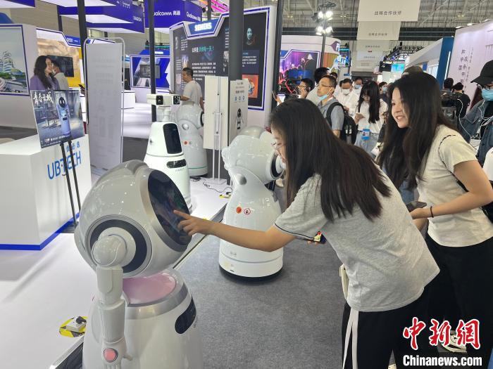 觀眾與參展企業(yè)的機(jī)器人互動?！⊥蹙?攝