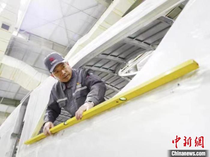 周晶輝正在測(cè)量車體外形平度?！∈茉L者供圖