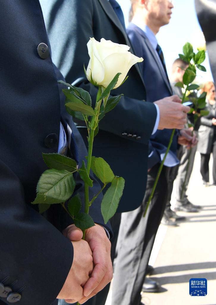 5月7日，在塞爾維亞貝爾格萊德中國駐南斯拉夫聯(lián)盟大使館舊址，人們手持鮮花參加憑吊儀式。（圖源：新華網(wǎng)）