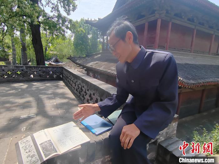圖為王永先向記者介紹其發(fā)表在雜志期刊上的文章?！「哂昵?攝