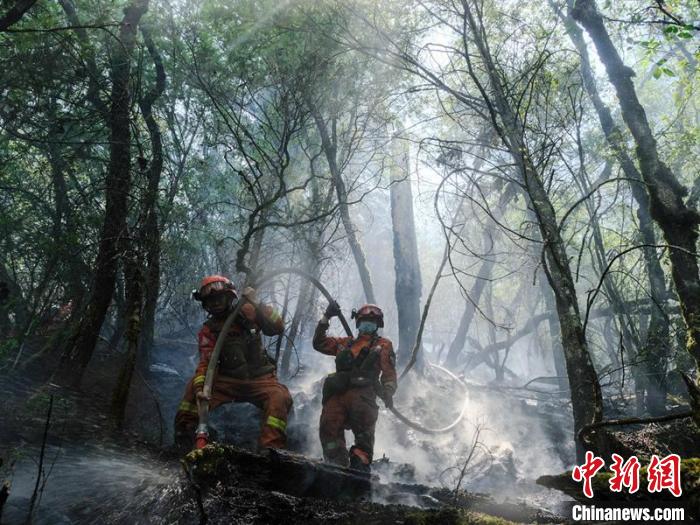 森林消防員正在木里火場(chǎng)清理地下火?！〕萄┝?攝