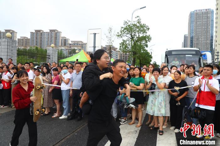 圖為蔣張子怡的父親背著她往外走，母親拿著女兒的滑板跟在后面?！⒄祭?攝