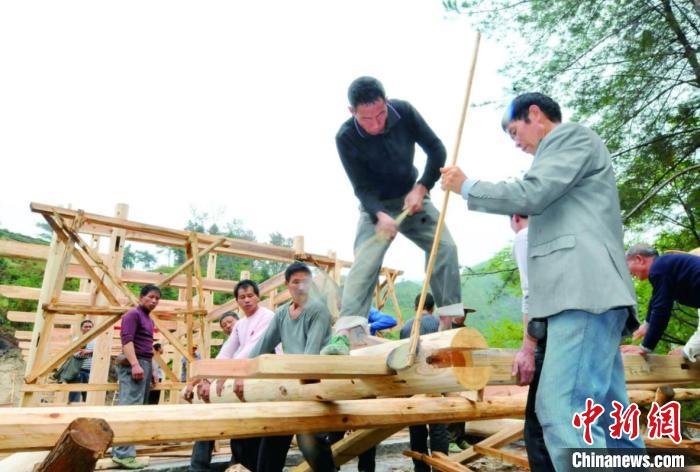 資料圖為木拱廊橋建造過程中，匠人們正在“搭屋架”?！↓徑?攝