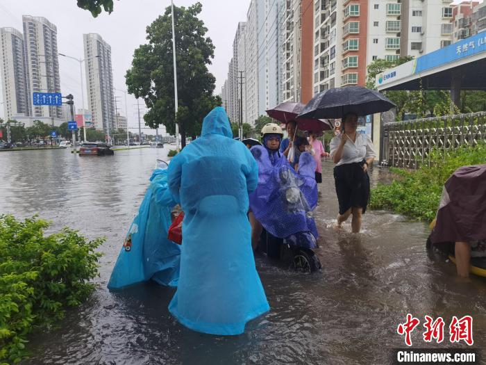 6月8日，強(qiáng)降雨過后，北海市民涉水出行。　翟李強(qiáng) 攝