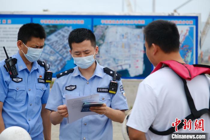 平潭邊檢站移民管理警察對船員證件進(jìn)行查驗(yàn)?！±钭谒?攝