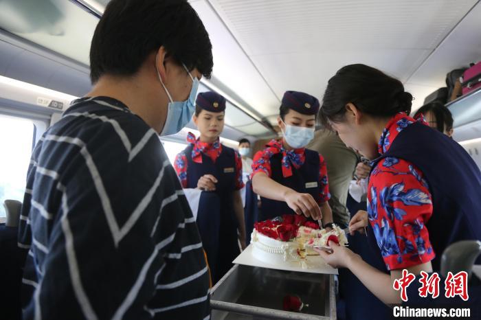 乘務(wù)員與旅客分享生日蛋糕?！≈軙躁?yáng) 攝
