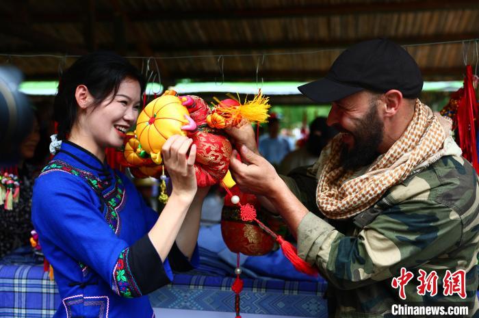 圖為一名來(lái)自德國(guó)的游客與身著民族服裝的壯族姑娘互動(dòng)?！畋厥?攝