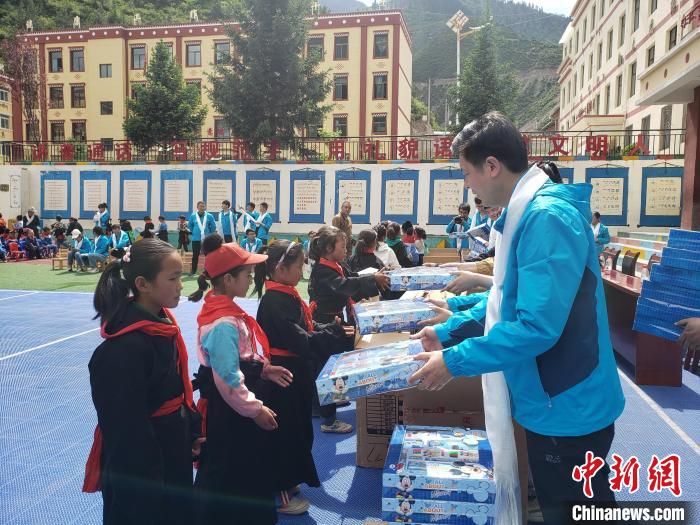 圖為公司員工代表給甘南州迭部縣多兒鄉(xiāng)中心小學(xué)的孩子們分發(fā)文具用品。(資料圖) 馬建斌 攝