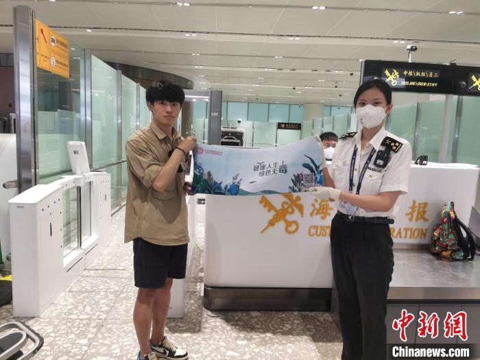 圖為大興機(jī)場海關(guān)對入境旅客進(jìn)行禁毒知識宣傳。　李尚澤 攝