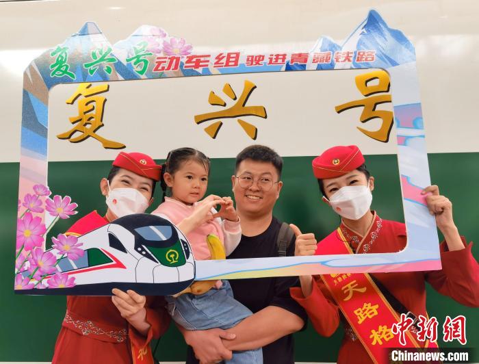 7月1日，旅客在西寧車站與“復(fù)興號”紀(jì)念牌合影留念。中新社記者 祁增蓓 攝