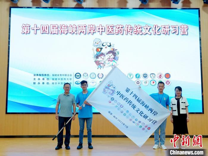 共青團(tuán)福建省委副書記吳雪(右一)、福建中醫(yī)藥大學(xué)黨委副書記林羽(左一)為兩岸學(xué)生代表頒授營旗。　許燁婷 攝