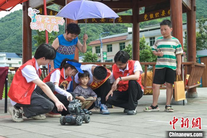 圖為學(xué)子們指導(dǎo)小朋友使用機器人?！￡愐圾Q 攝
