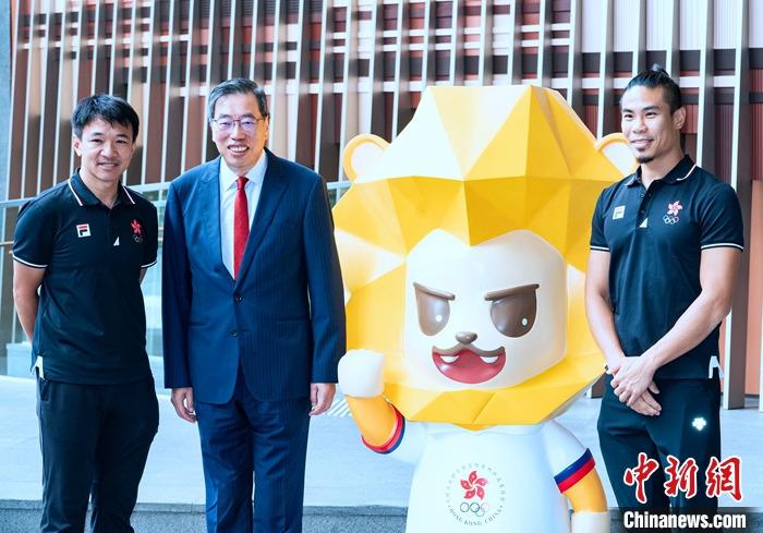 7月5日，香港立法會主席梁君彥在立法會綜合大樓出席為即將出征杭州2022年第19屆亞運(yùn)會的中國香港代表團(tuán)加油打氣活動。圖為梁君彥(左二)與香港前自行車運(yùn)動員黃金寶(左一)、前空手道運(yùn)動員李嘉維(右一)在本屆中國香港代表團(tuán)吉祥物獅子“堅仔”旁合影。 <a target='_blank' href='/'>中新社</a>記者 侯宇 攝