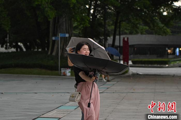 大風(fēng)將一名市民的雨傘吹翻?！￡愺K旻 攝