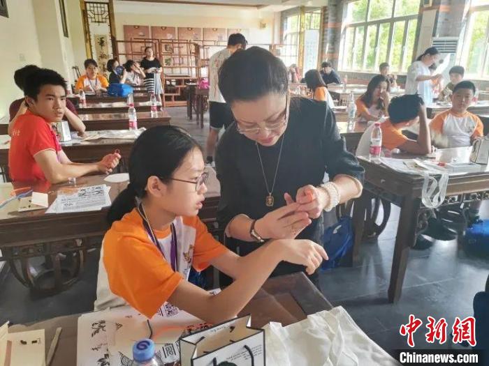 珊麗娜指導(dǎo)華裔少年做盤扣?！∩虾Ｊ袃S聯(lián)供圖